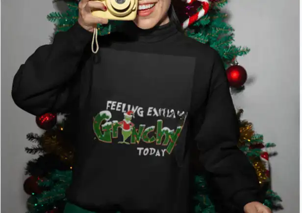 Grenchy Bliss Unisex Sweater: Female wearing the festive sweater in front of a Christmas tree, radiating holiday cheer.