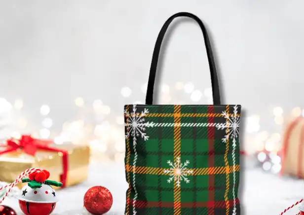 Winter Whispers Plaid Tote Bag - Front view of the classic green plaid design with delicate snowflakes